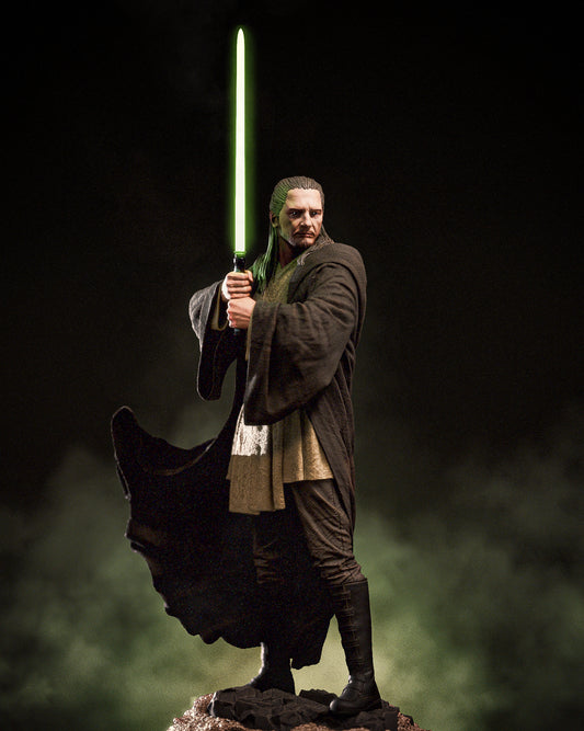 Painted Qui-Gon Jinn statue with glowing green lightsaber.